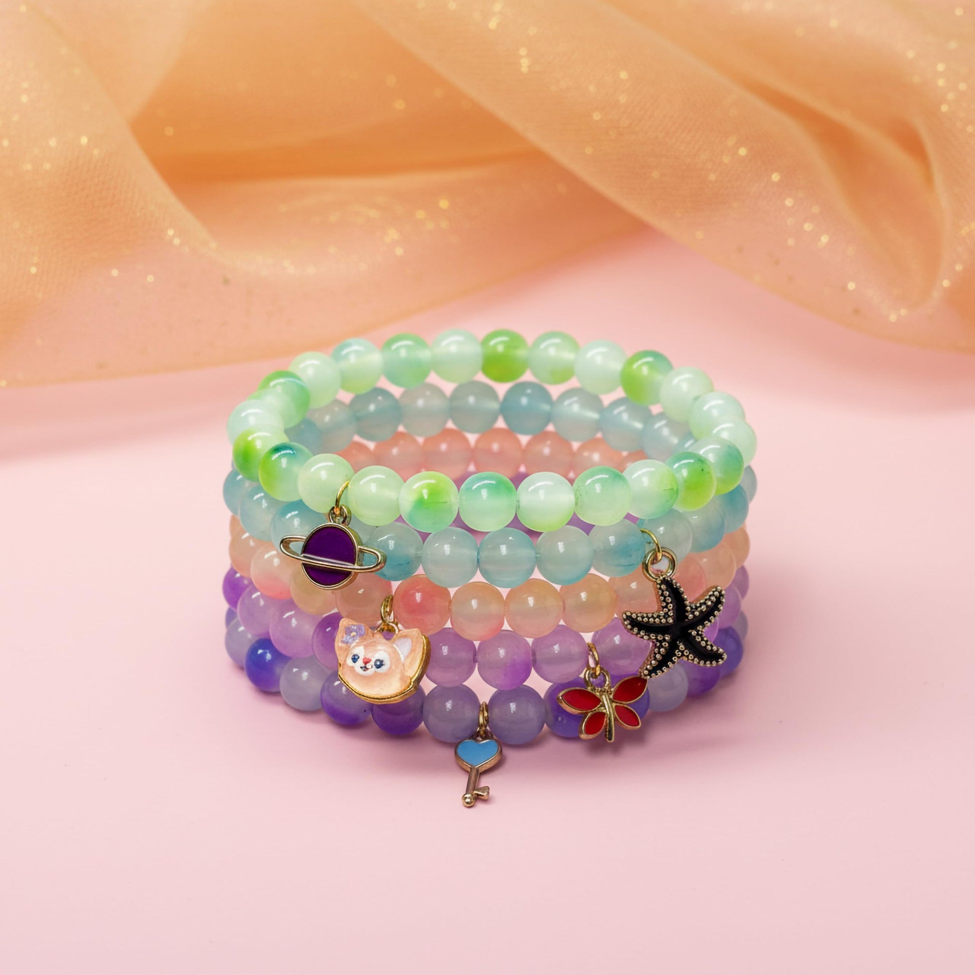 Layer cute wrist stacks with multicolor dualtone bead details and charm accents.