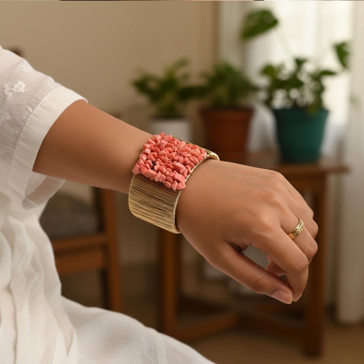 Layer outfits with a textured pink stone chip bracelet for a strong modern finish.