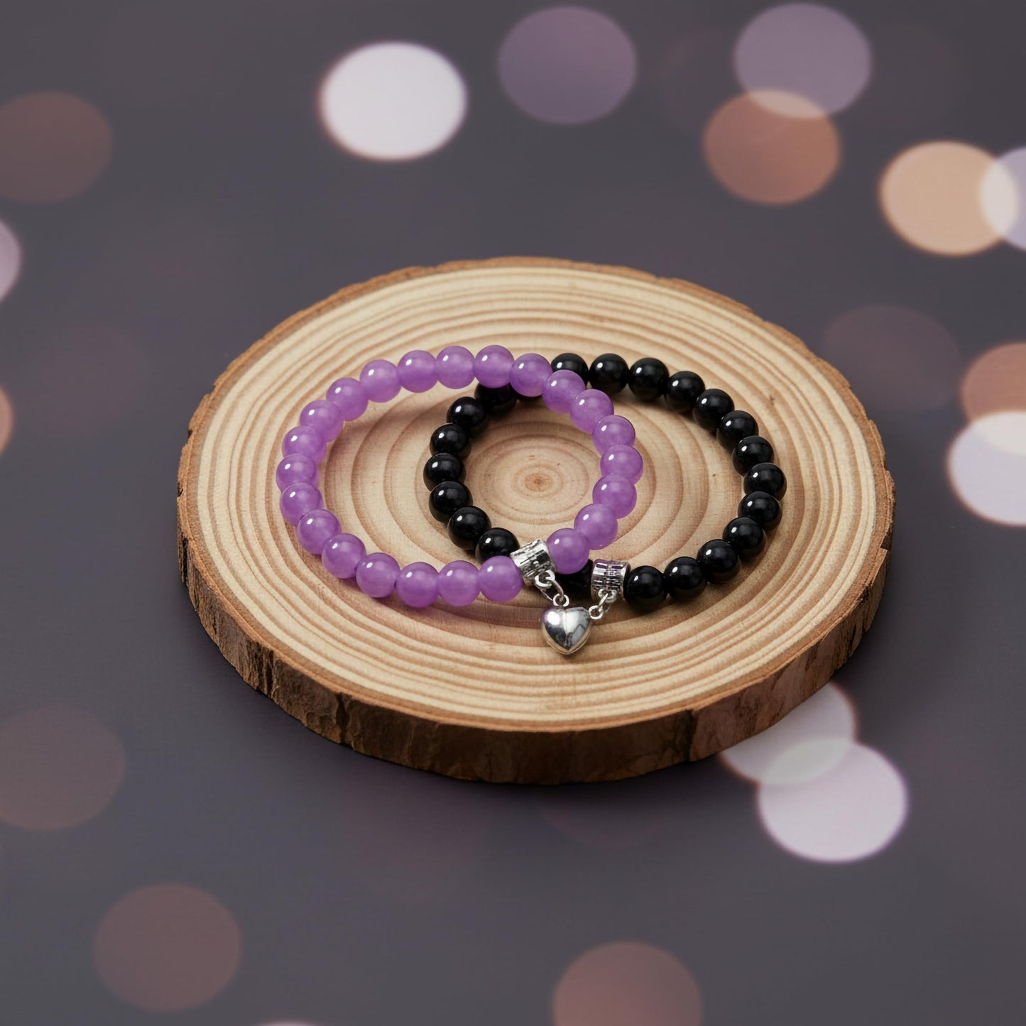 Create a sweet paired wrist look using black and purple 1-pair cord bracelets with connecting heart charms.