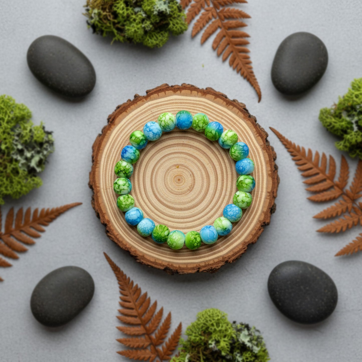 Make matching hand bands feel stylish with green and blue matte marble beads and simple stretch wear.