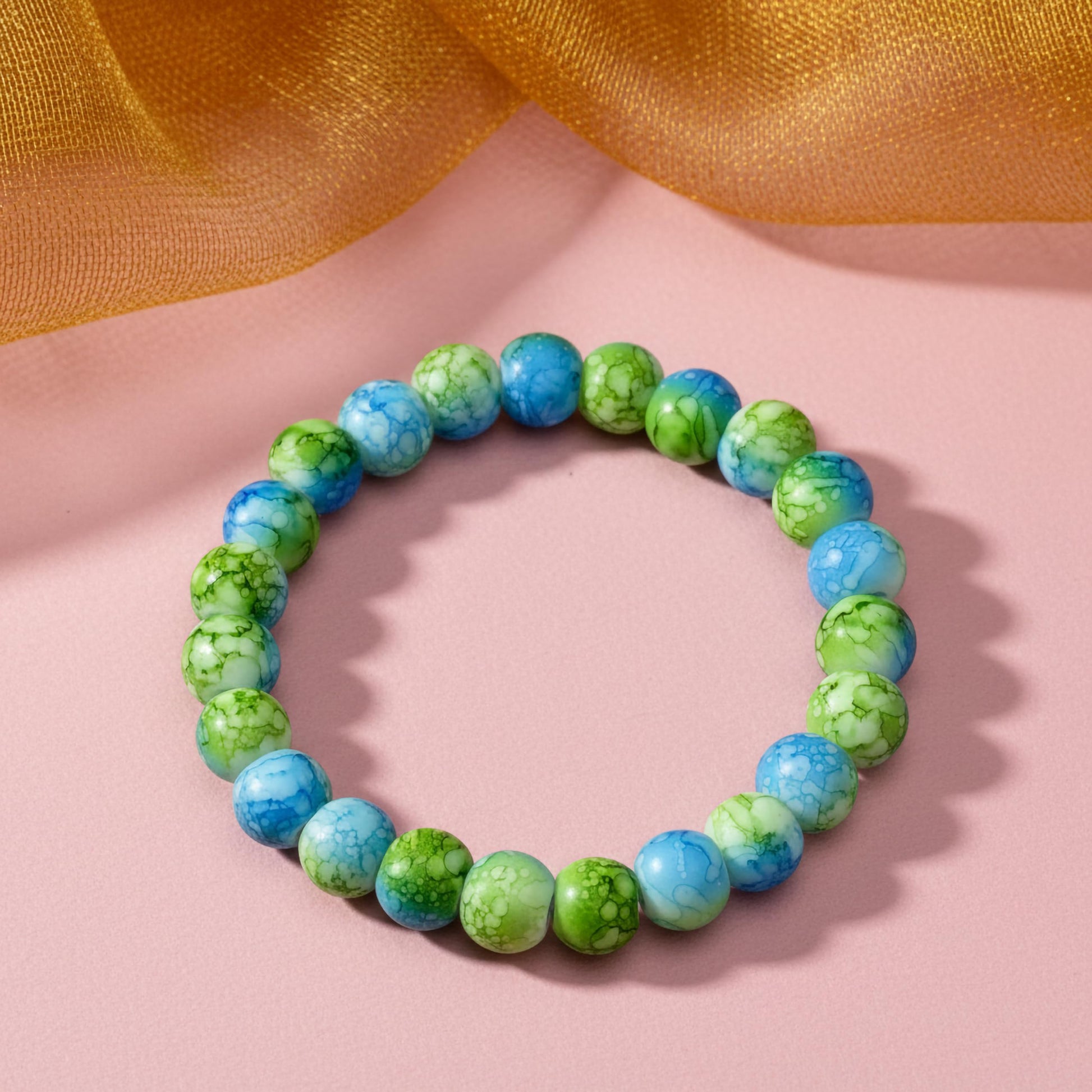Bring playful color texture to stacked bracelets with green and blue rounded marble-style beads.