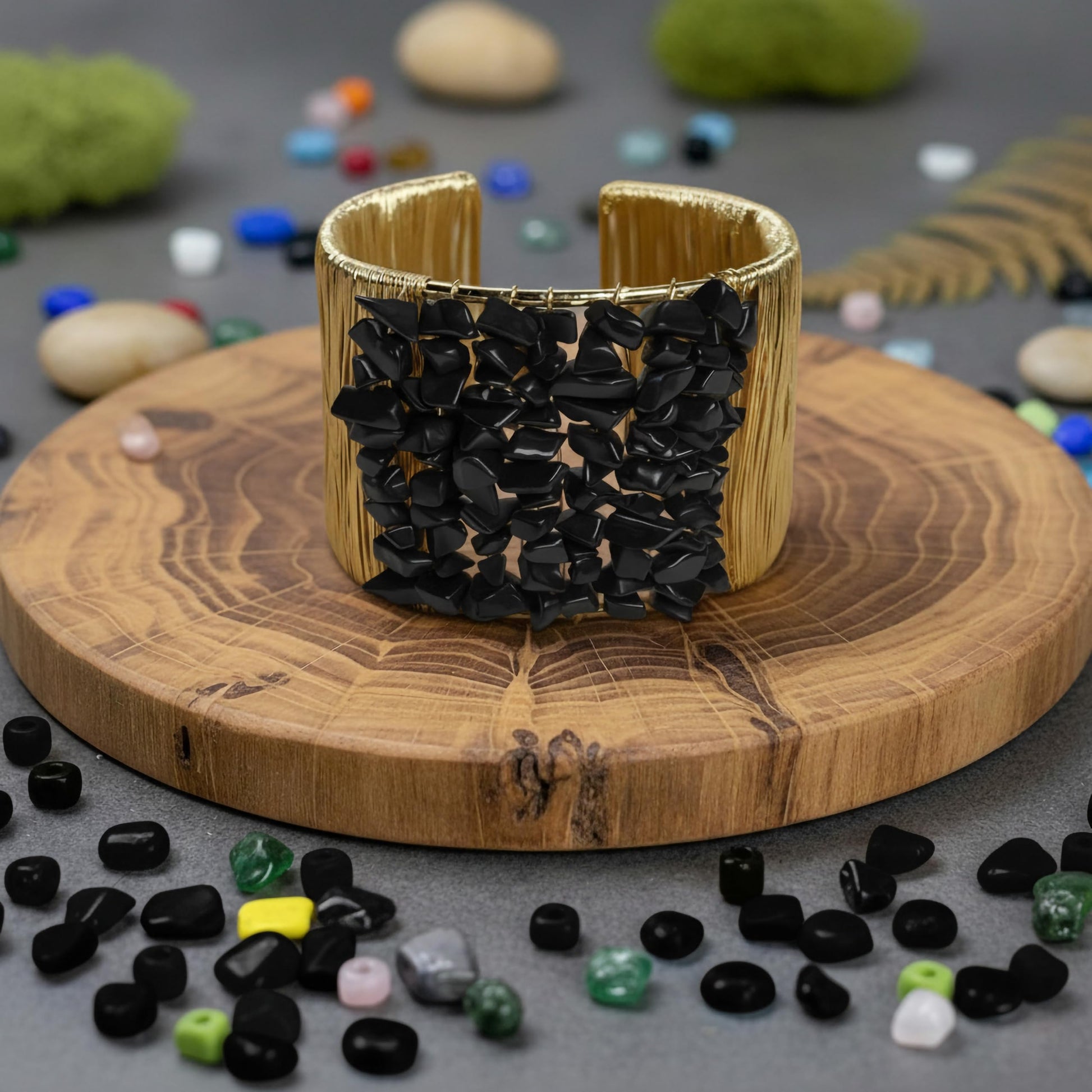 Style a statement bracelet look with black gemstone chips and sculpted gold-tone wire.