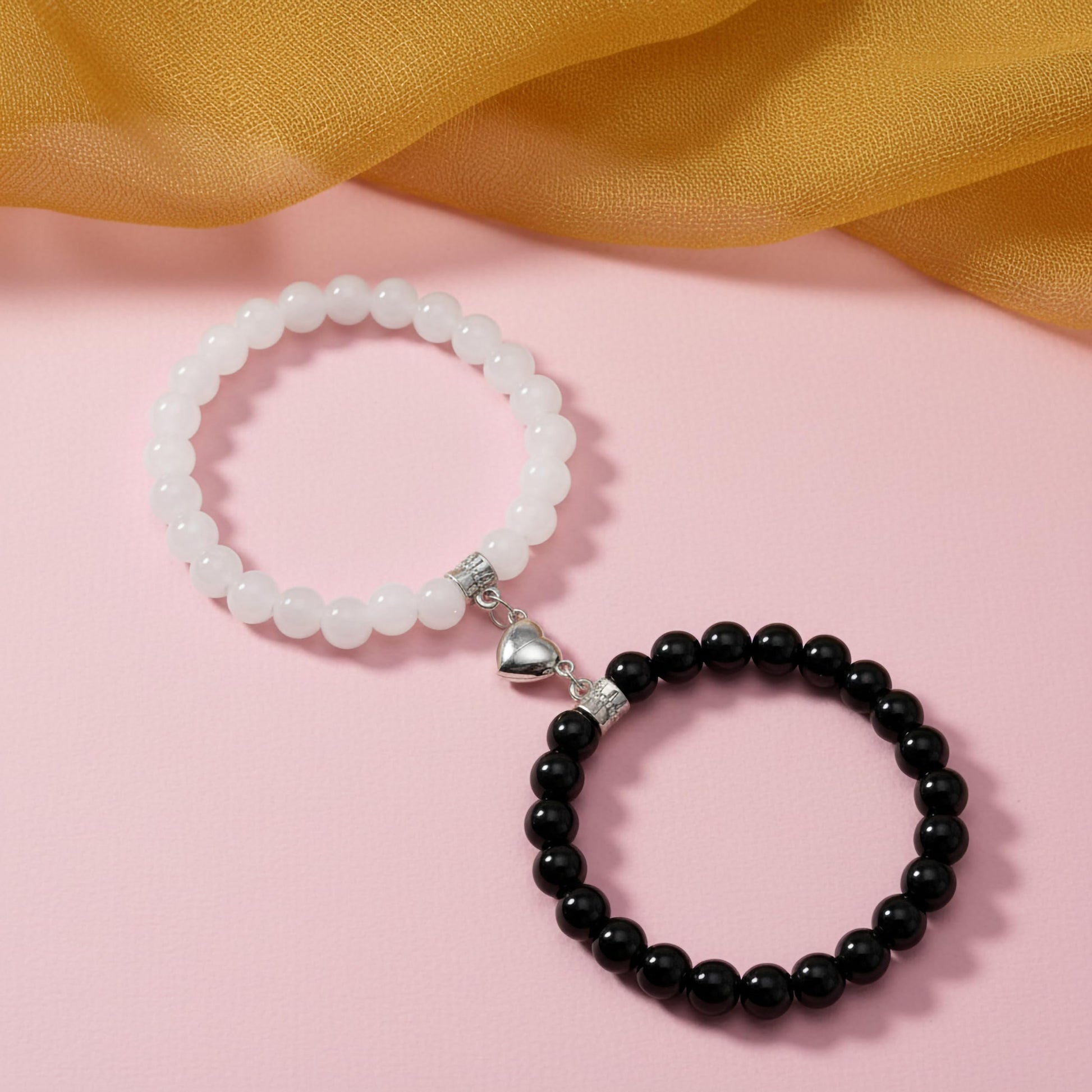 Keep couple looks cute and coordinated with white and black 1-pair heart-link magnetic bracelets.