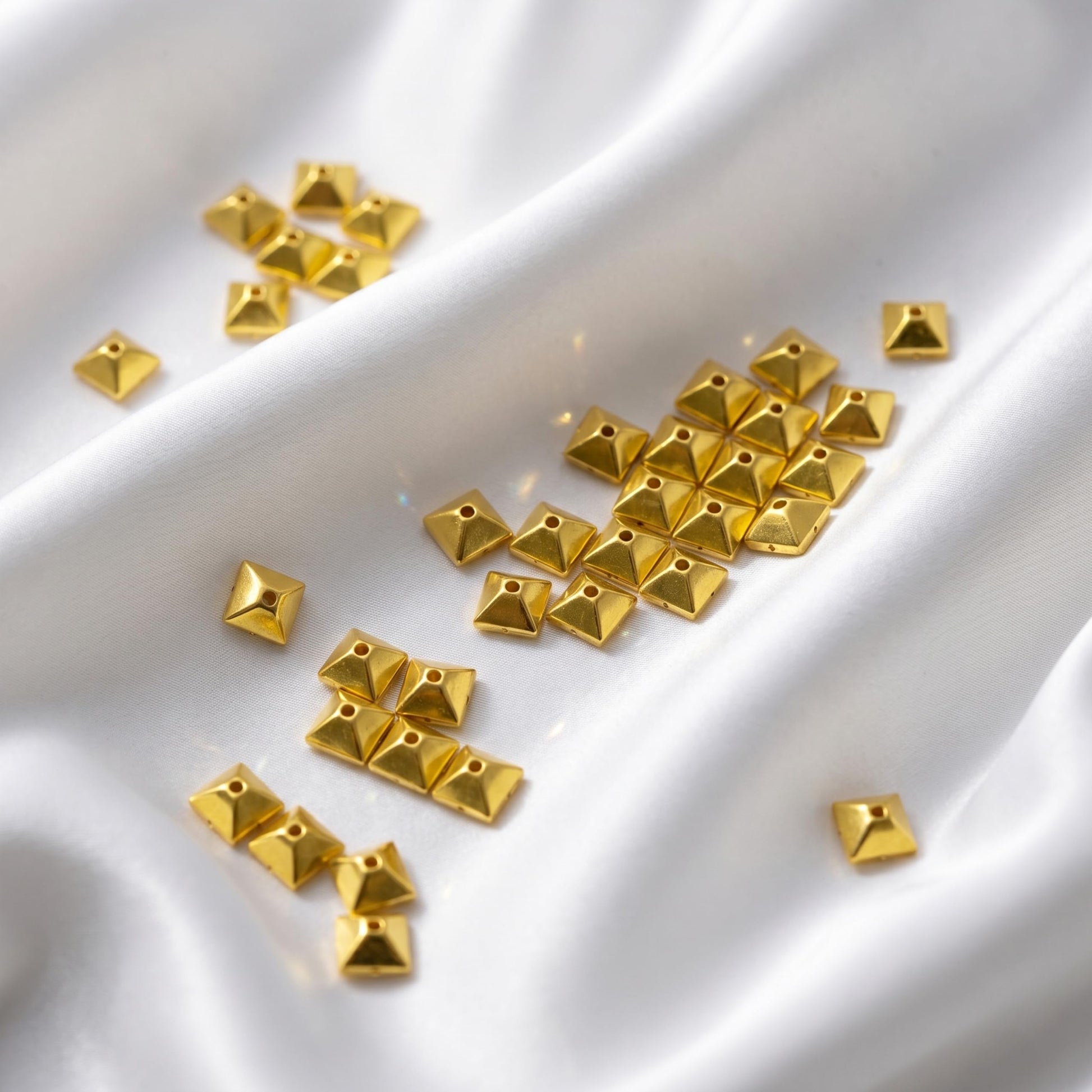 These festive gold pyramid chamki pieces bring festive shine to dress decoration and boutique craft projects.