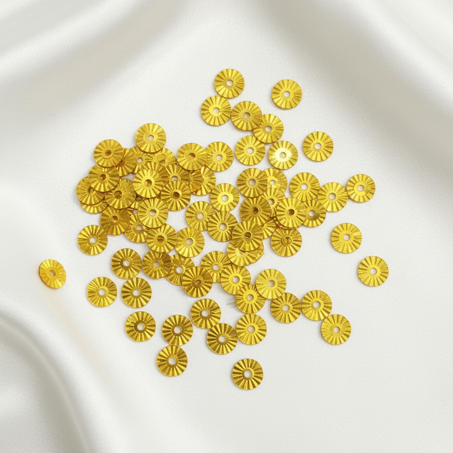 Let festive gold metallic sequin embellishments add festive shine to dress decoration and boutique craft projects.
