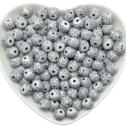White round beads with black speckled pattern in heart tray